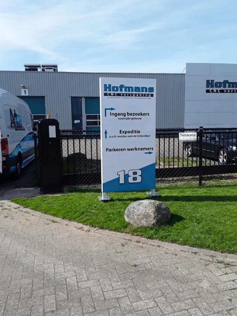 Reclamezuil met bedrijfsnamen bij de ingang van een bedrijfsterrein